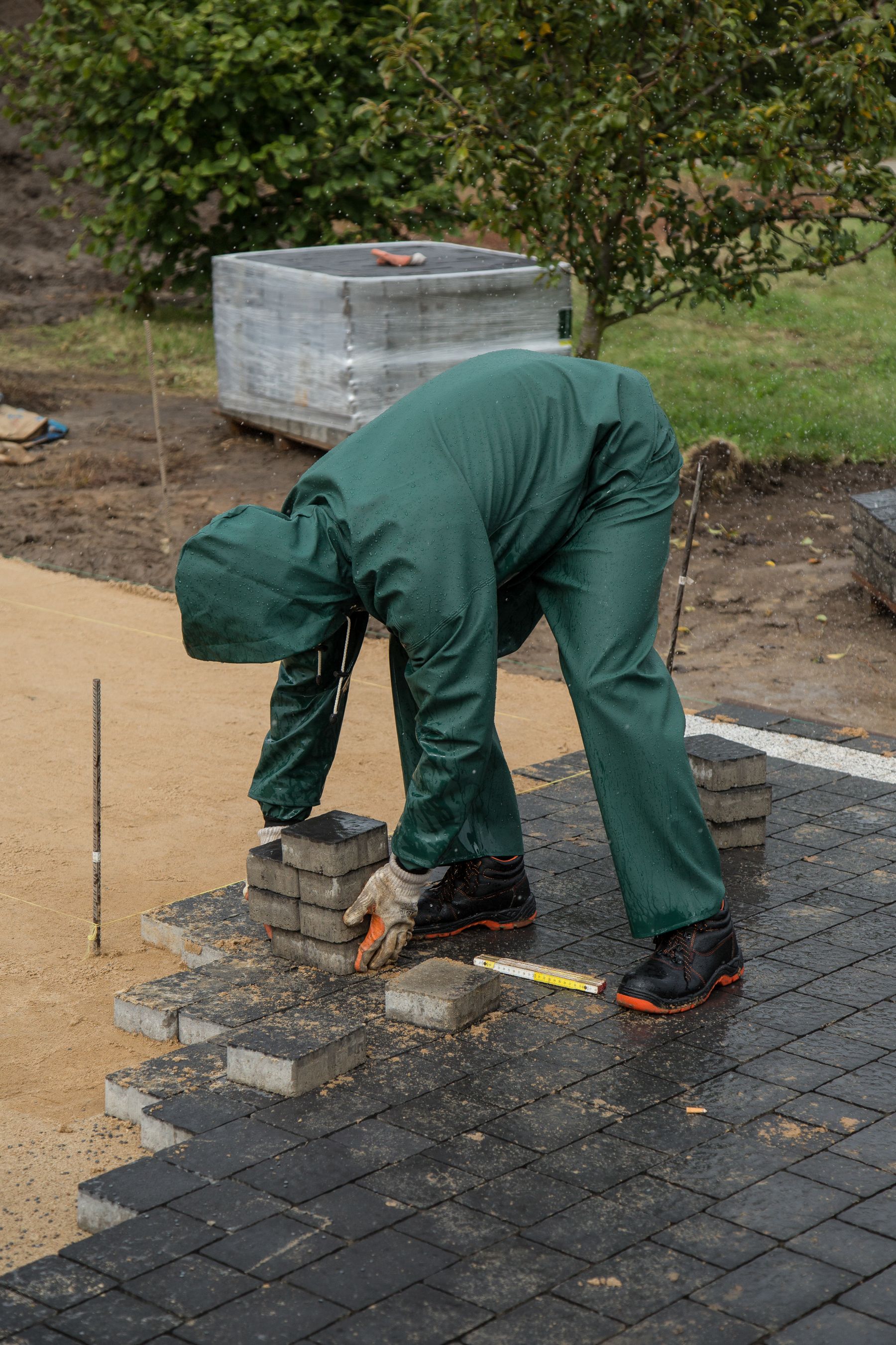 Landscape worker carefully installing patio pavers
