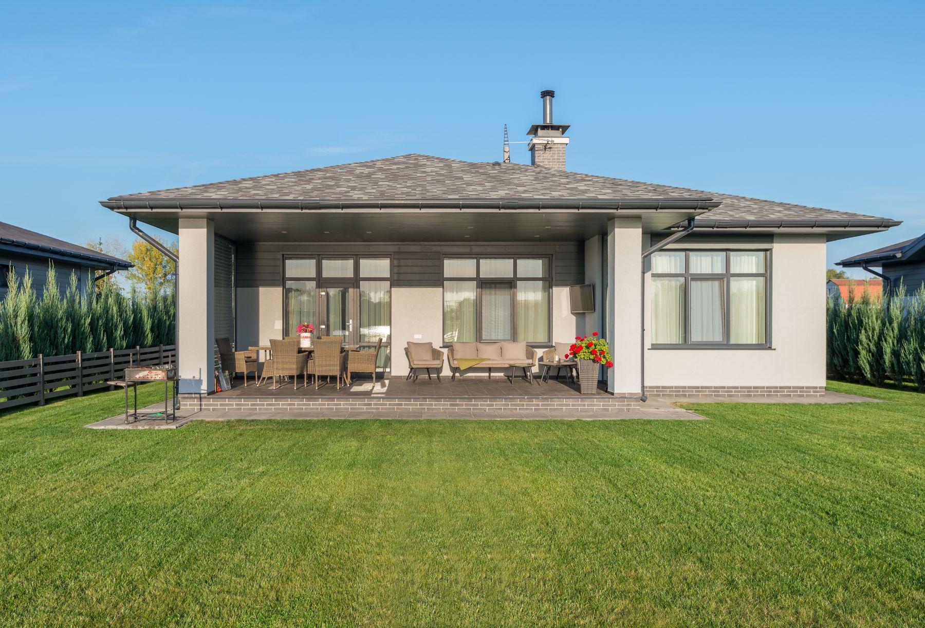 Large, neatly maintained backyard lawn beside an outdoor patio